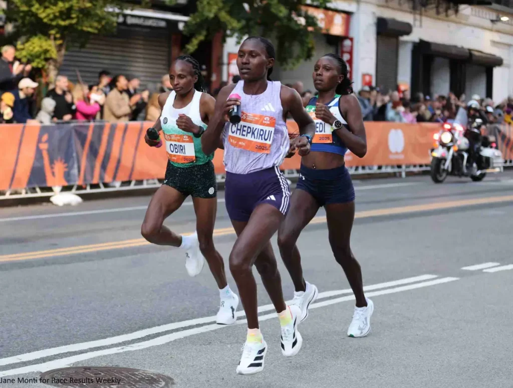 Hellen Obiri, Sharon Lokedi and Sheila Chepkirui after descending the Queensboro Bridge in the 17th mile of the 2025 TCS New York City Marathon