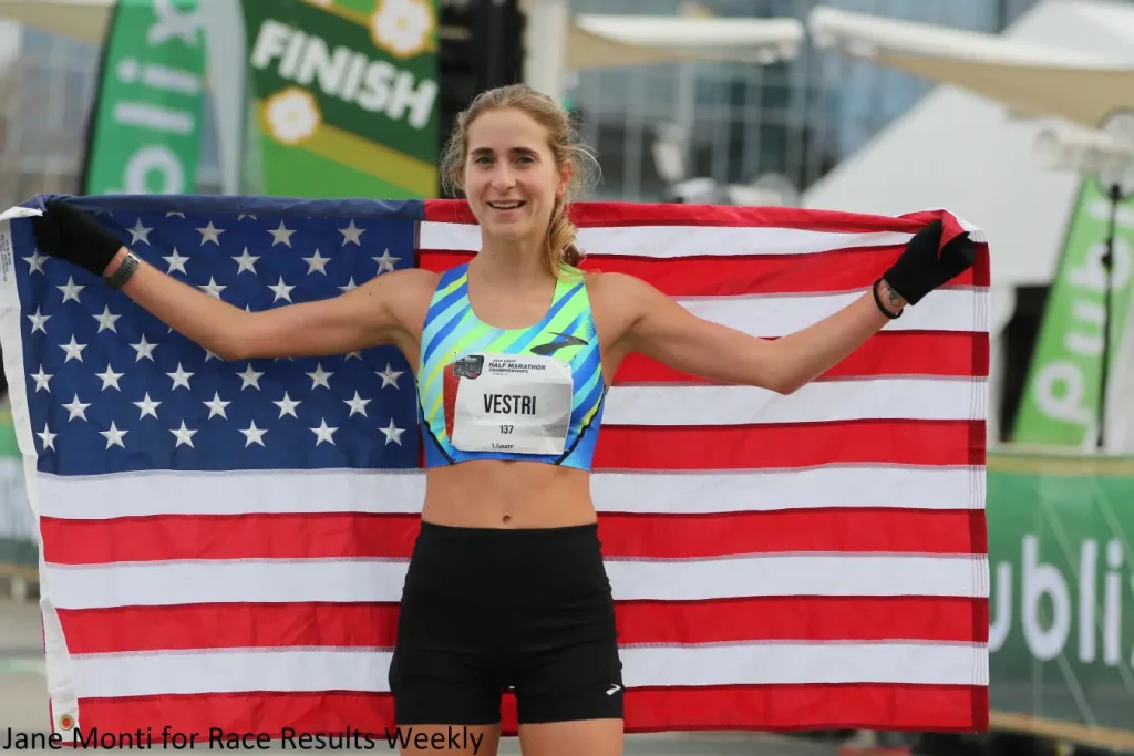 Amanda Vestri with the USA flag at the 2025 USATF Half-Marathon Championships 2025